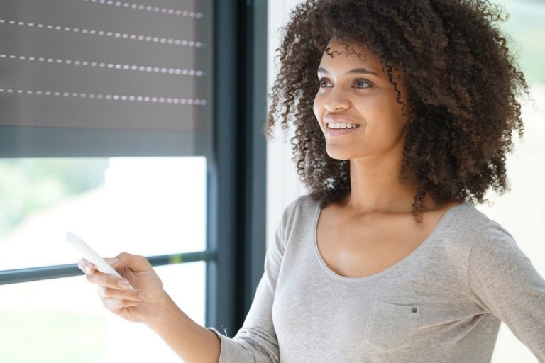 Femme qui ferme ses volets roulants